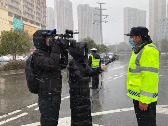 孝感市融媒體中心楊亞玲（風(fēng)雪中，采訪疫情期間重返一線的退休警察）_副本.jpg.jpg